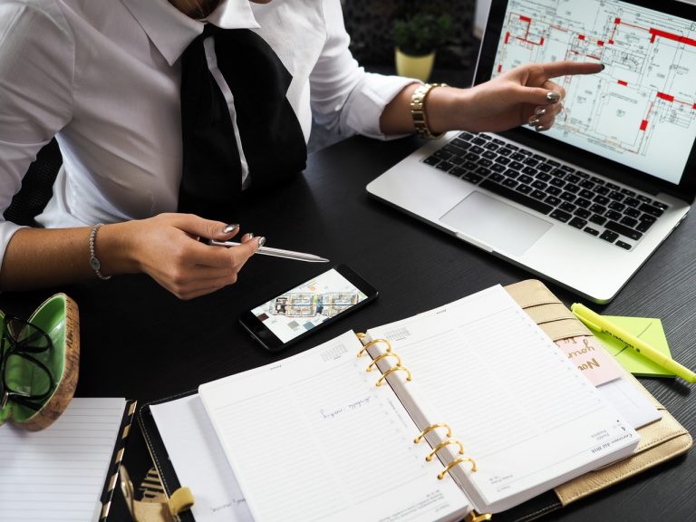 Business owner working at a desk with a laptop and notepad