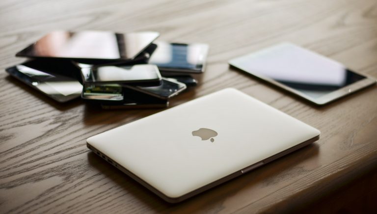 Laptop, notebook and smartphone laid out on a desk